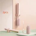 Pink and green electric rotating bottle cleaning brush with silicone bristles on a white background.