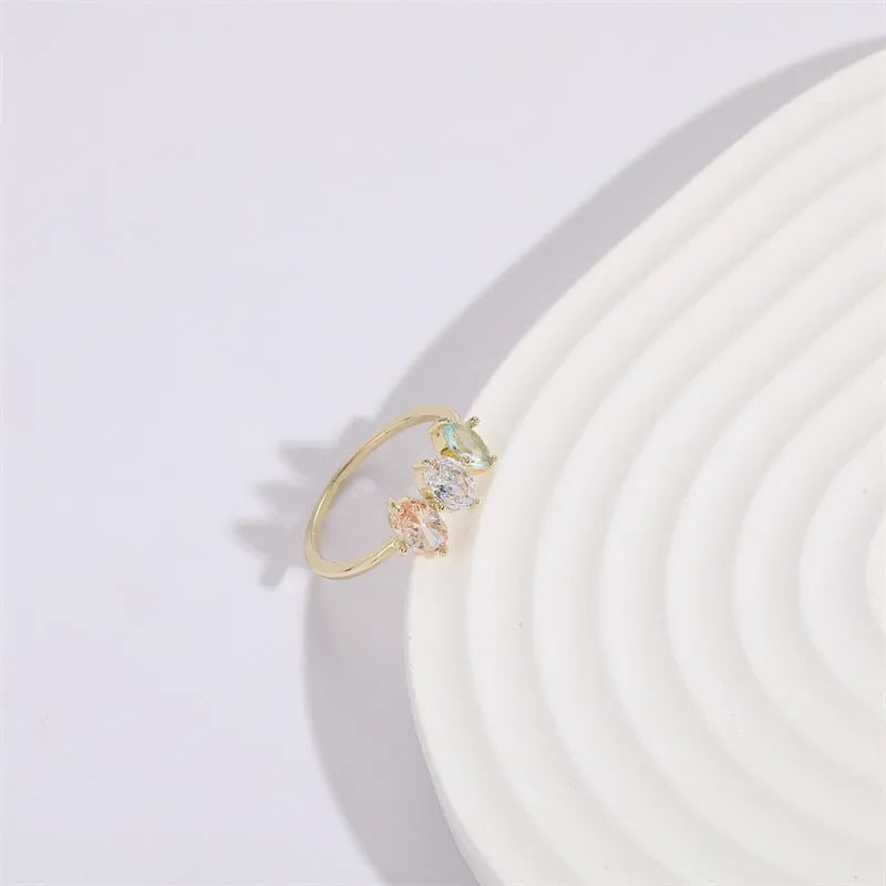 Geometric copper ring with a triangular tricolour zircon birthstone in a horse eye design, showing 14k gold electroplated finish.