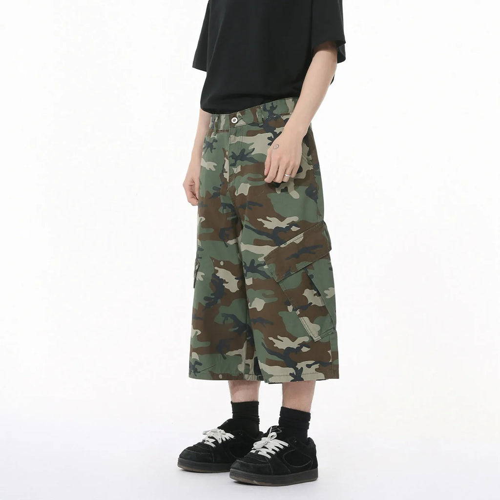 Men's cotton camouflage wide-leg cargo trousers with cropped length on a neutral background.