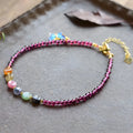 Purple garnet geometric anklet for women on an ankle.