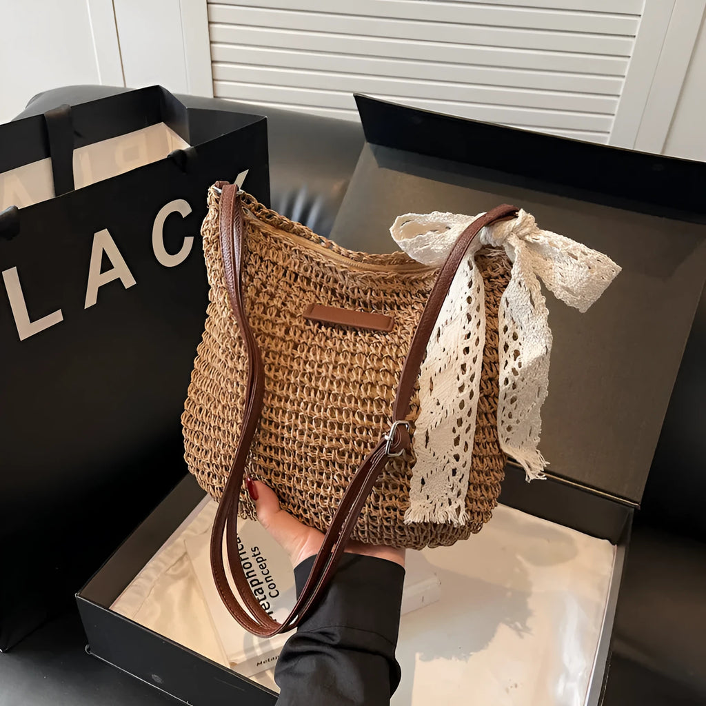Women's woven straw messenger bag in khaki colour, showing hollowed texture and single shoulder strap.