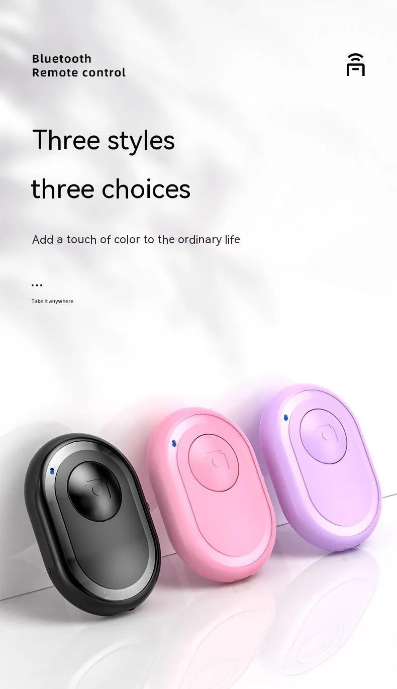 Wireless Bluetooth self-timer remote control in black, pink, and purple colours next to a smartphone.