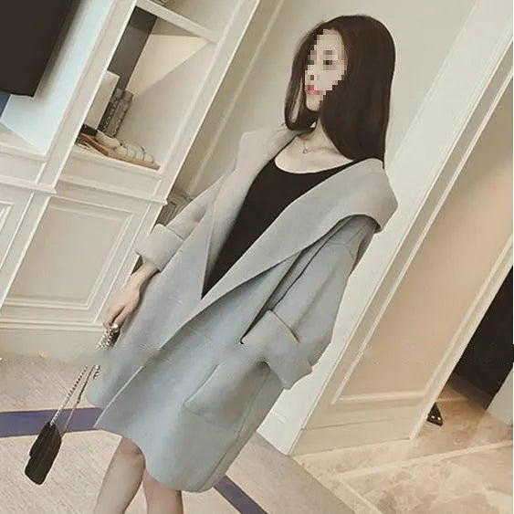 Plus size woman wearing a thin, loose-fit grey coat with lace detail and long sleeves.