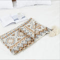 Bohemian-style acrylic knit sofa blanket with tassels in a geometric pattern
