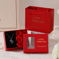 Red Valentine's gift box open to show six pink soap roses with a matching handbag beside it