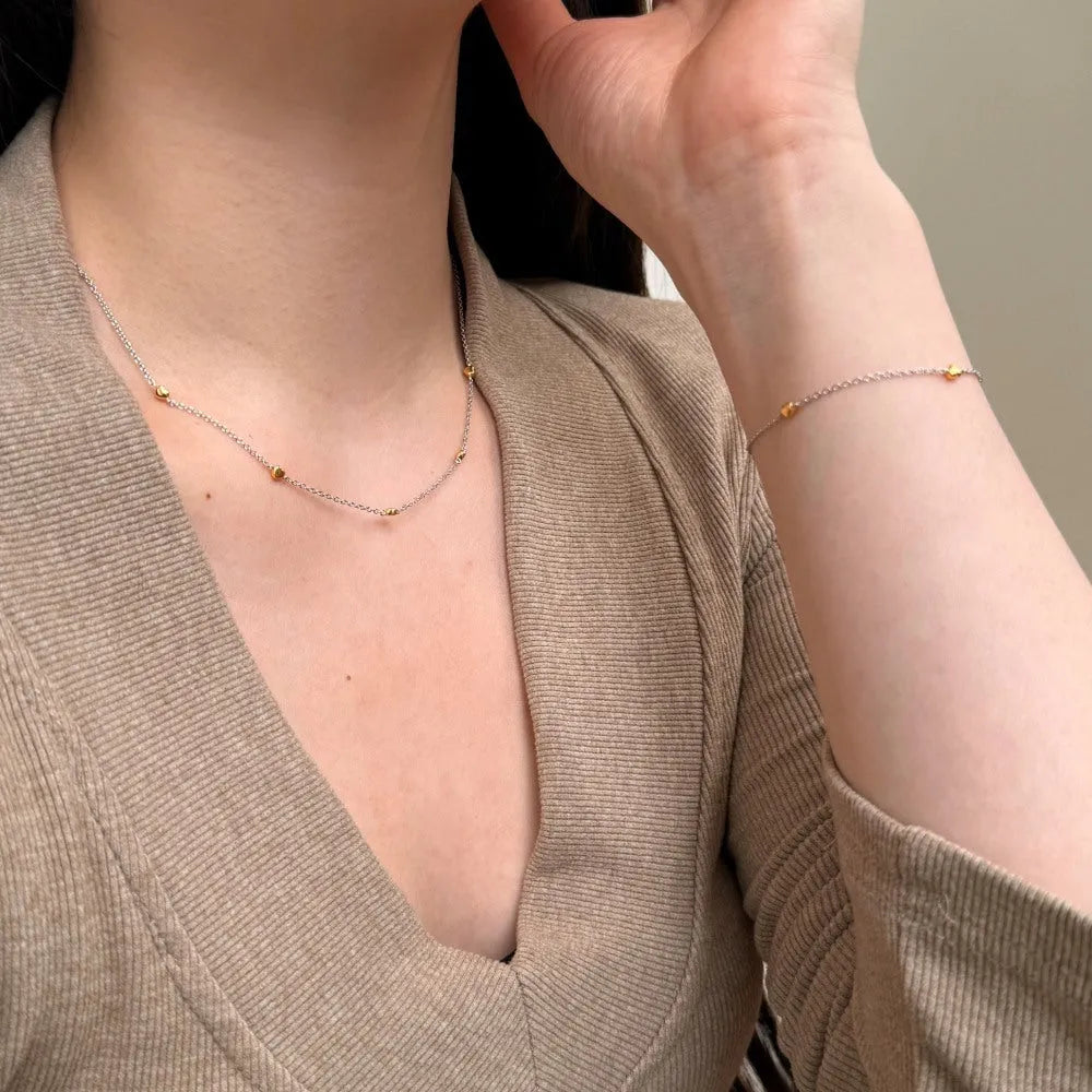 Light luxury silver necklace and bracelet set with platinum electroplated finish on white background