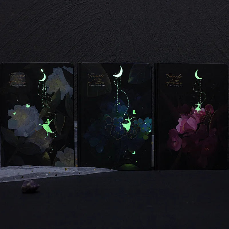 A5 spiral-bound notebook with a luminous coloured cover, open to show lined pages with colour illustrations.