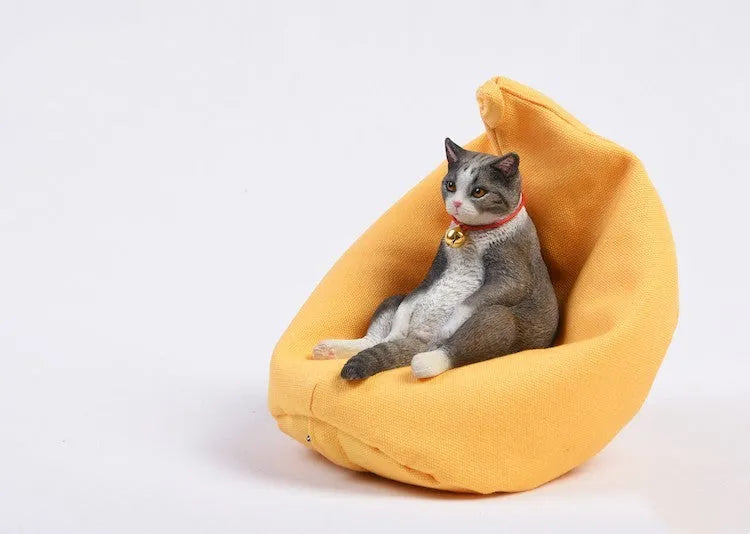 Small resin cat figurine on a sofa, a 1:6 scale car dashboard ornament.