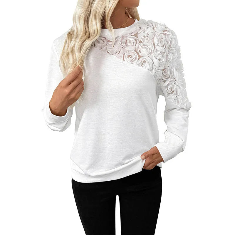 White long sleeve loose fit top with floral pattern on a hanger.