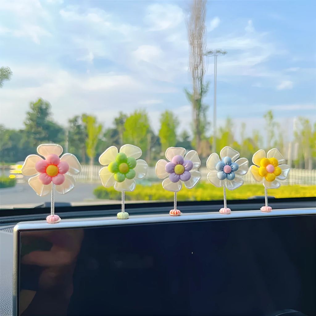 Small colourful plastic car decoration shaped like a swing, shown in blue, on a car dashboard.