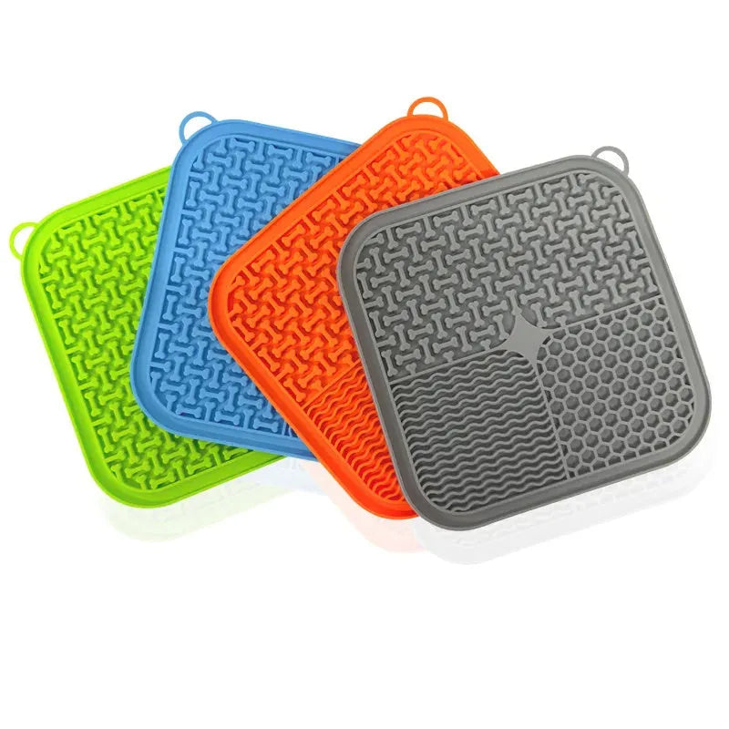 Orange, grey, blue and green silicone dog licking mat with suction cups on back measuring 20x20cm