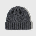 Woman wearing a knitted wool beanie with a dome crown and tribal totem pattern in Ankela Red.