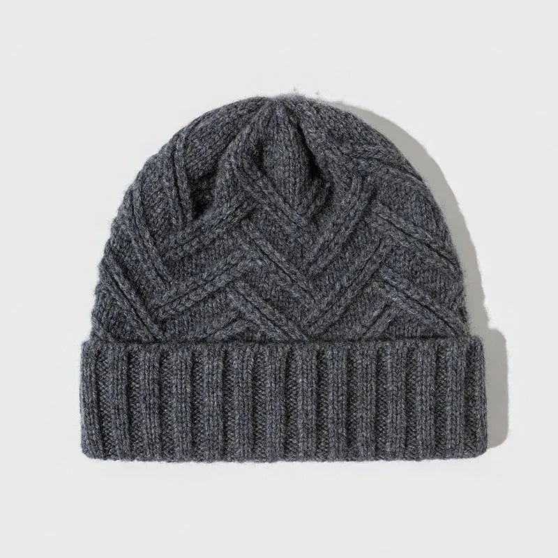 Woman wearing a knitted wool beanie with a dome crown and tribal totem pattern in Ankela Red.