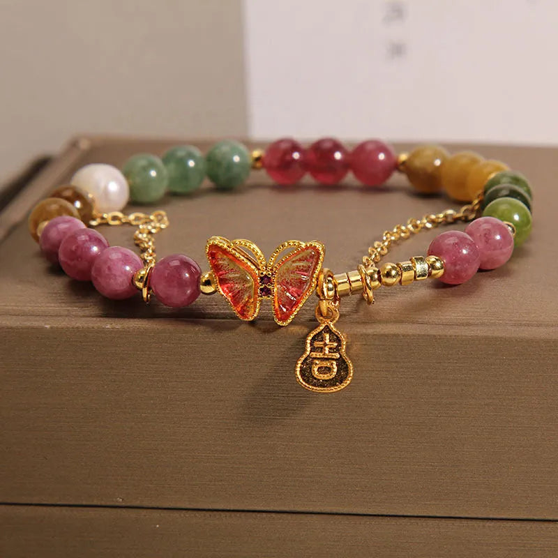 Natural jade coloured agate bracelet with a butterfly gourd tourmaline charm on an elasticated cord.