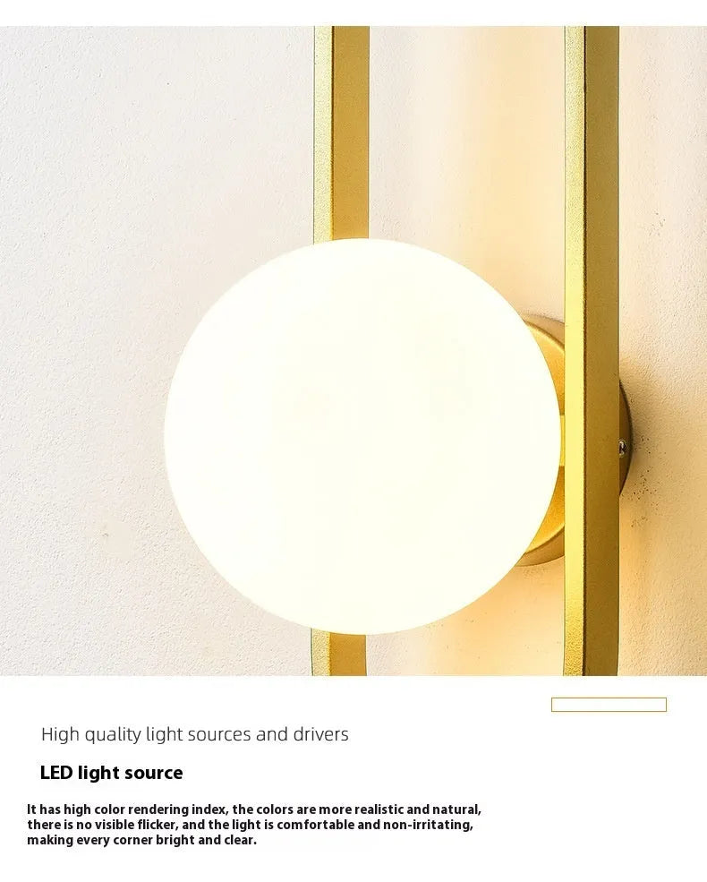 Minimalist circular wall lamp with glass shade on iron arm, in black finish, mounted beside a bed.