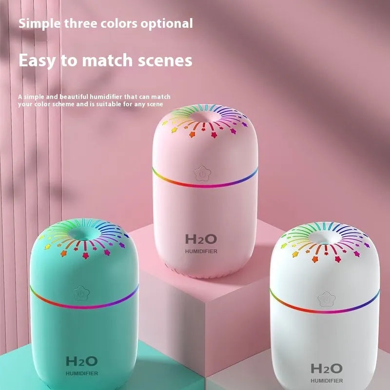 White USB portable mini humidifier with water tank on desk beside laptop