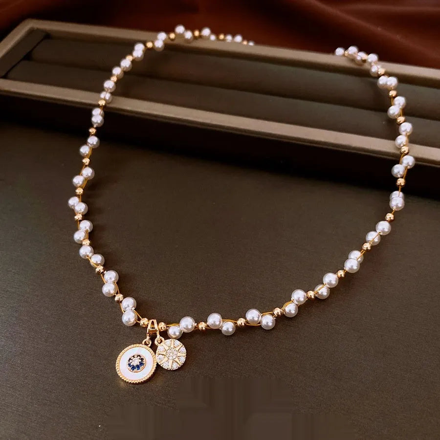 Gold electroplated necklace with round zircon and imitation pearl geometric pendant on an adjustable chain.