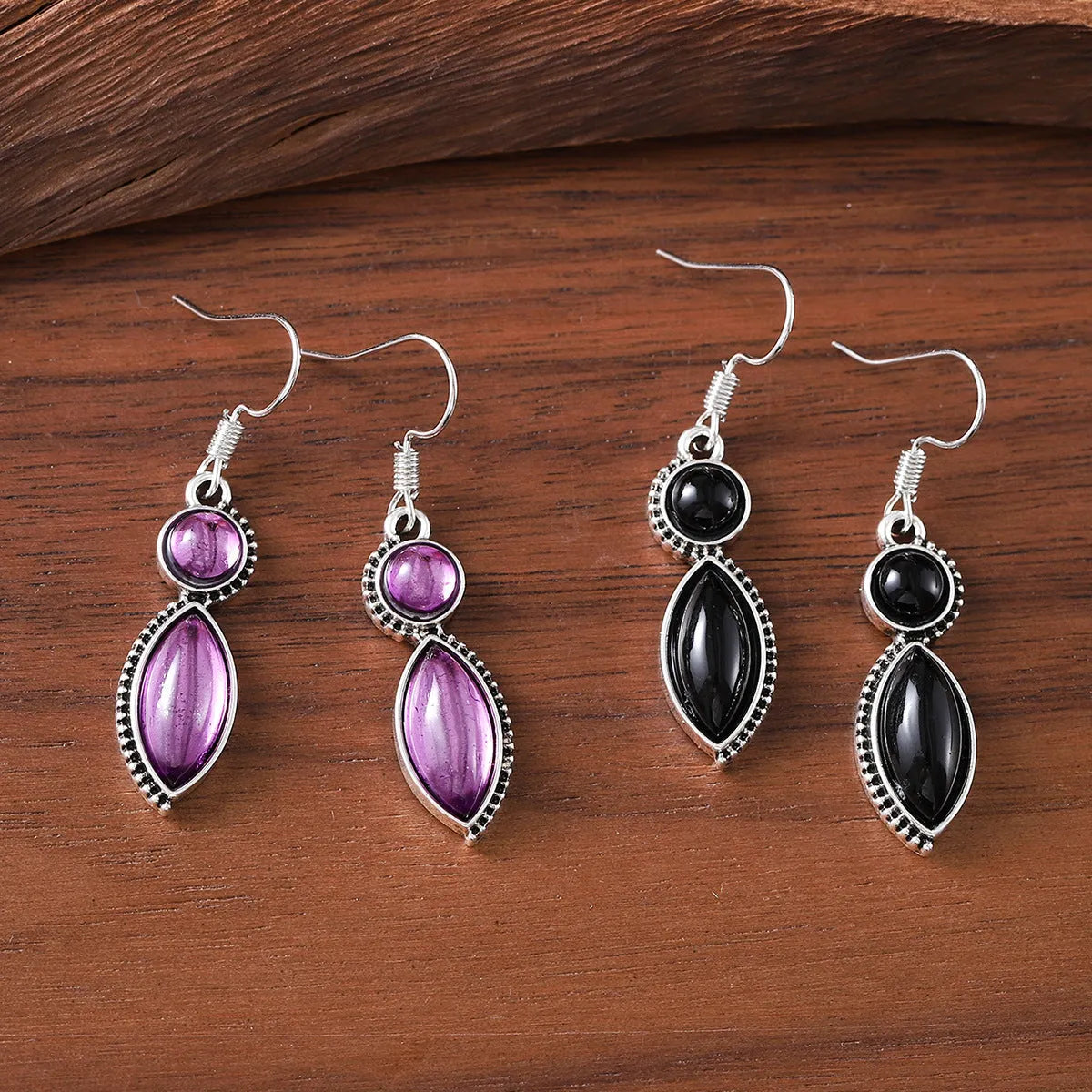 A pair of vintage-style geometric pendant earrings with purple and black stones on a zinc alloy frame.