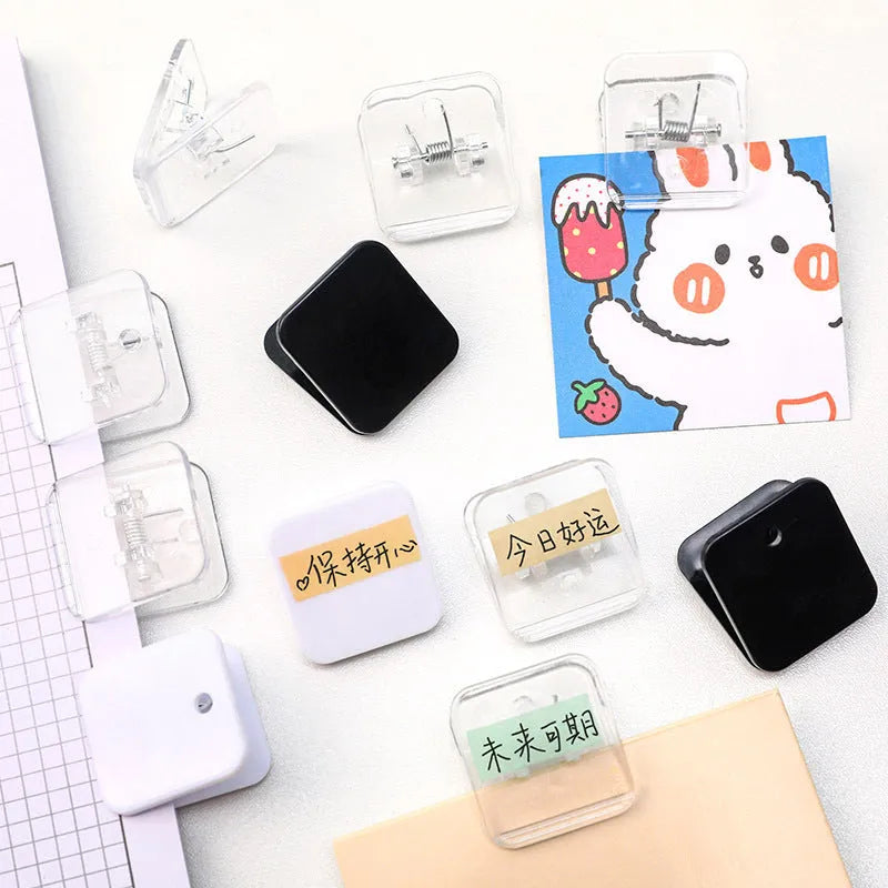 Square plastic photo memo holder in black, white, or transparent on a desk.