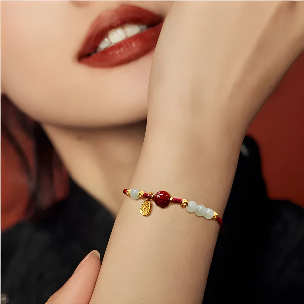 Adjustable silver bracelet with red Hetian jade detail on a wrist.