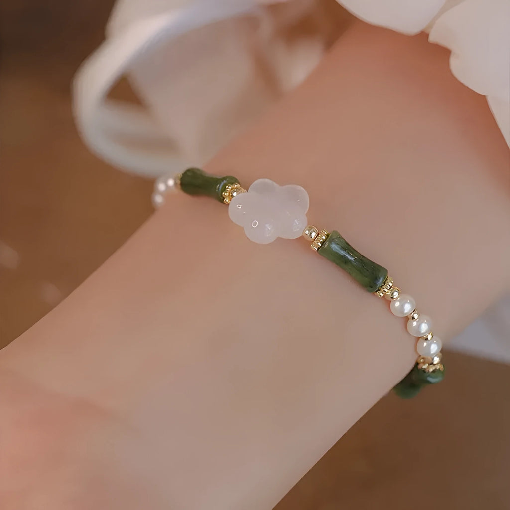 Close-up of a handcrafted Chinese antique style bracelet with bamboo joint design, featuring Hetian jade and 4mm shell pearls with copper details.