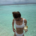 Women's orange polyester bikini with briefs bottom on a white background.