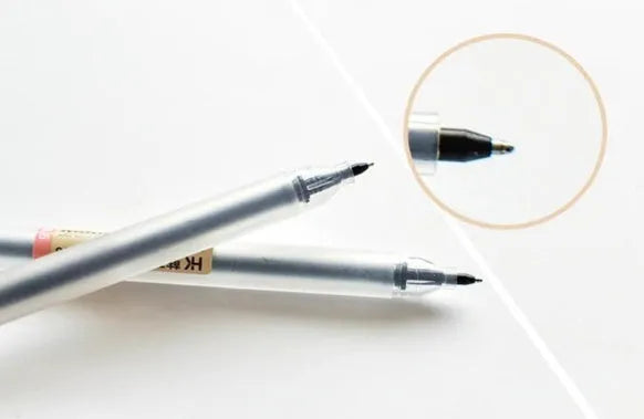 Muji 12-pack of clear barrel gel pens with 0.5mm fine nibs and visible ink, arranged neatly.