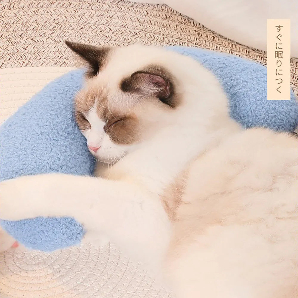 Blue U-shaped cat pillow with a white adjustable padded collar on a grey sofa.