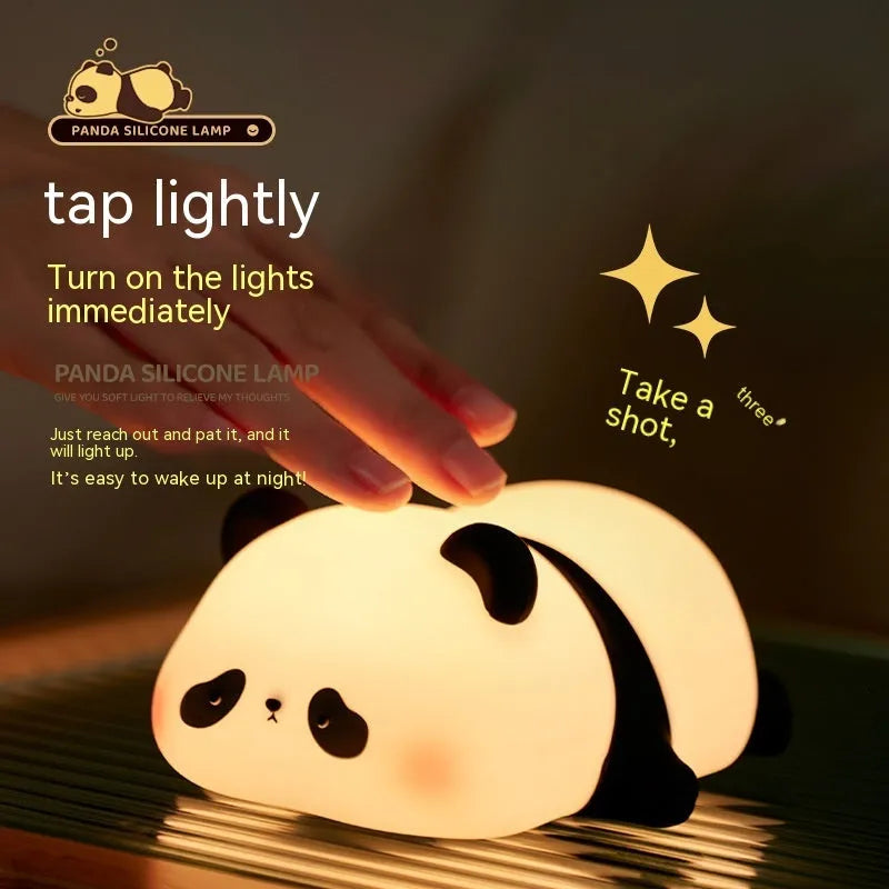 Cartoon panda head shaped silicone night light for children on a bedside table.