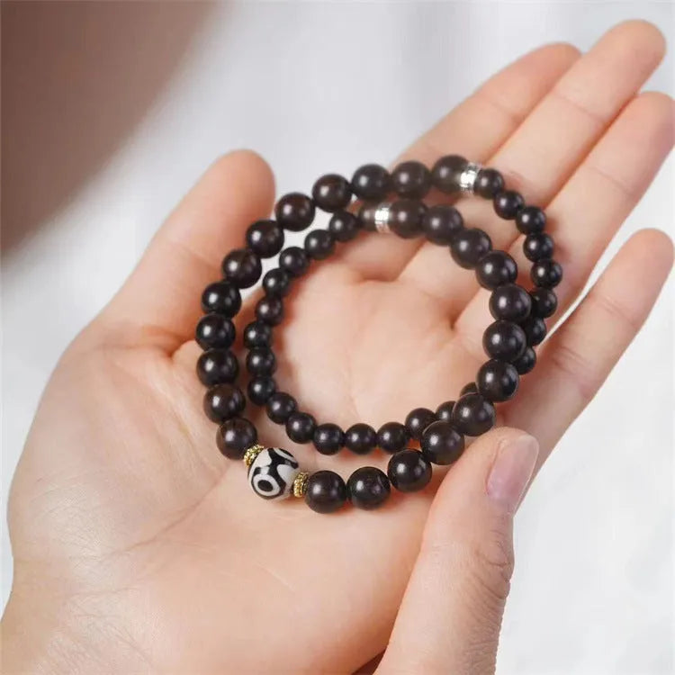 Close-up of Tibetan-style ebony wood bead bracelet showing 8mm diameter beads in two-circle layered design