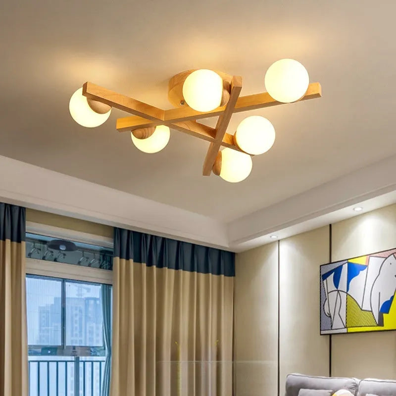 Modern black and copper three-headed pendant ceiling light with adjustable arms hanging over a wooden table