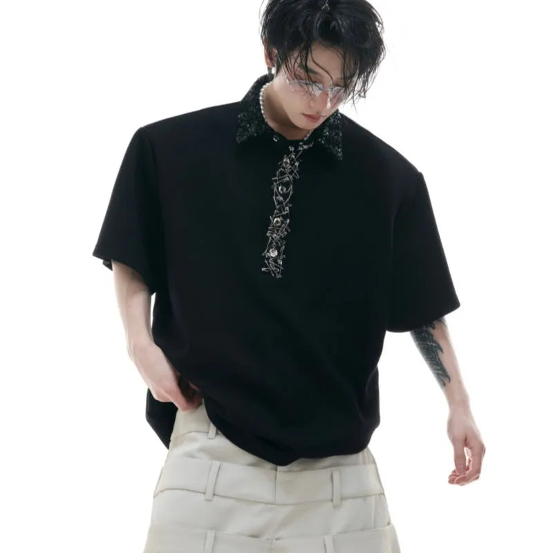 A man's black loose-fit polo t-shirt with heavy embroidery sequins detail and a square collar.