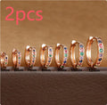 Circle-shaped cubic zirconia stud earrings in gold, rose gold, and silver colours on a white background.