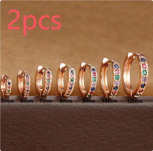 Circle-shaped cubic zirconia stud earrings in gold, rose gold, and silver colours on a white background.