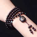 Zambia rosewood Buddha beads bracelet with 0.6 cm beads and flat lotus pendant on wooden surface