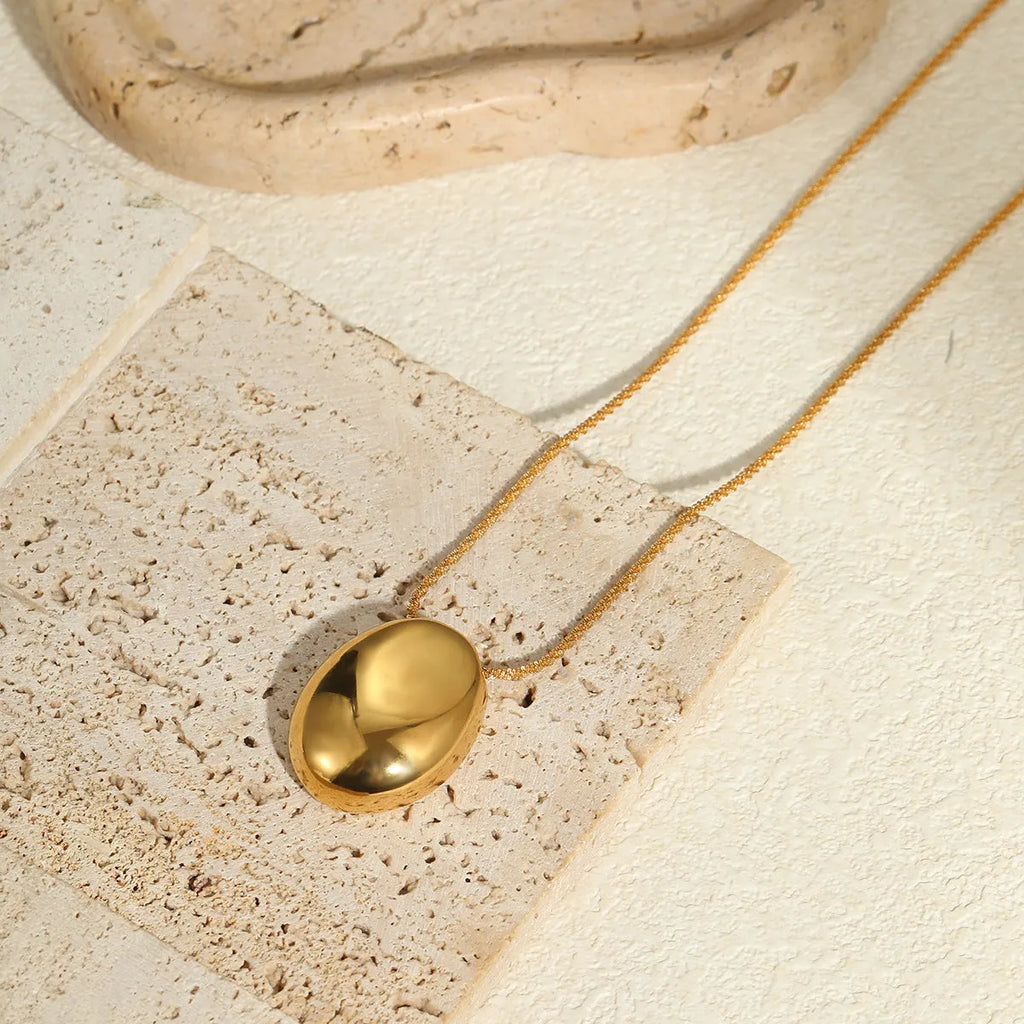 Gold geometric pendant necklace on a stainless steel chain with adjustable length.