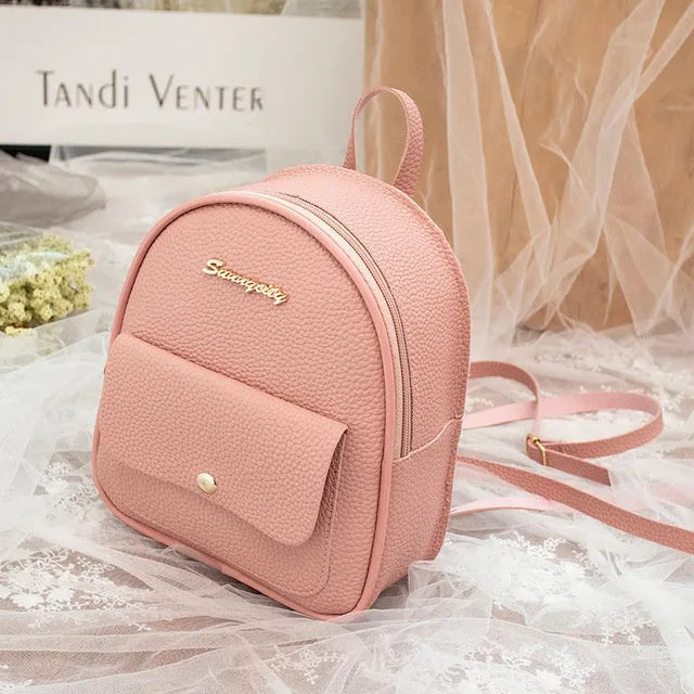 Small black PU women's letter-shaped shoulder bag worn as a backpack.