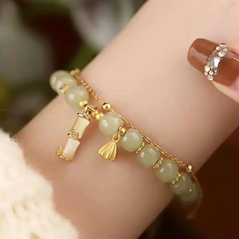 Bamboo-themed bracelet with a coloured glass flower and ruyi pattern in beige, green, light green, or white.