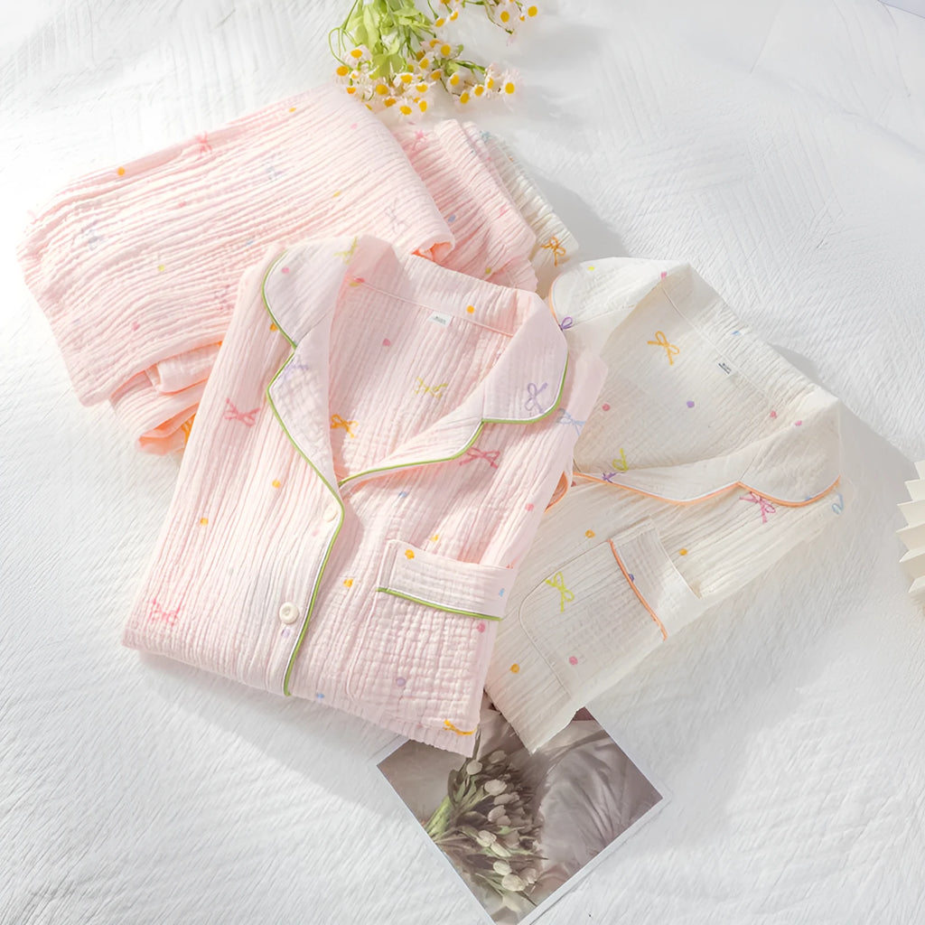 Women's beige thin cotton long sleeve pajama top and trousers set laid flat.