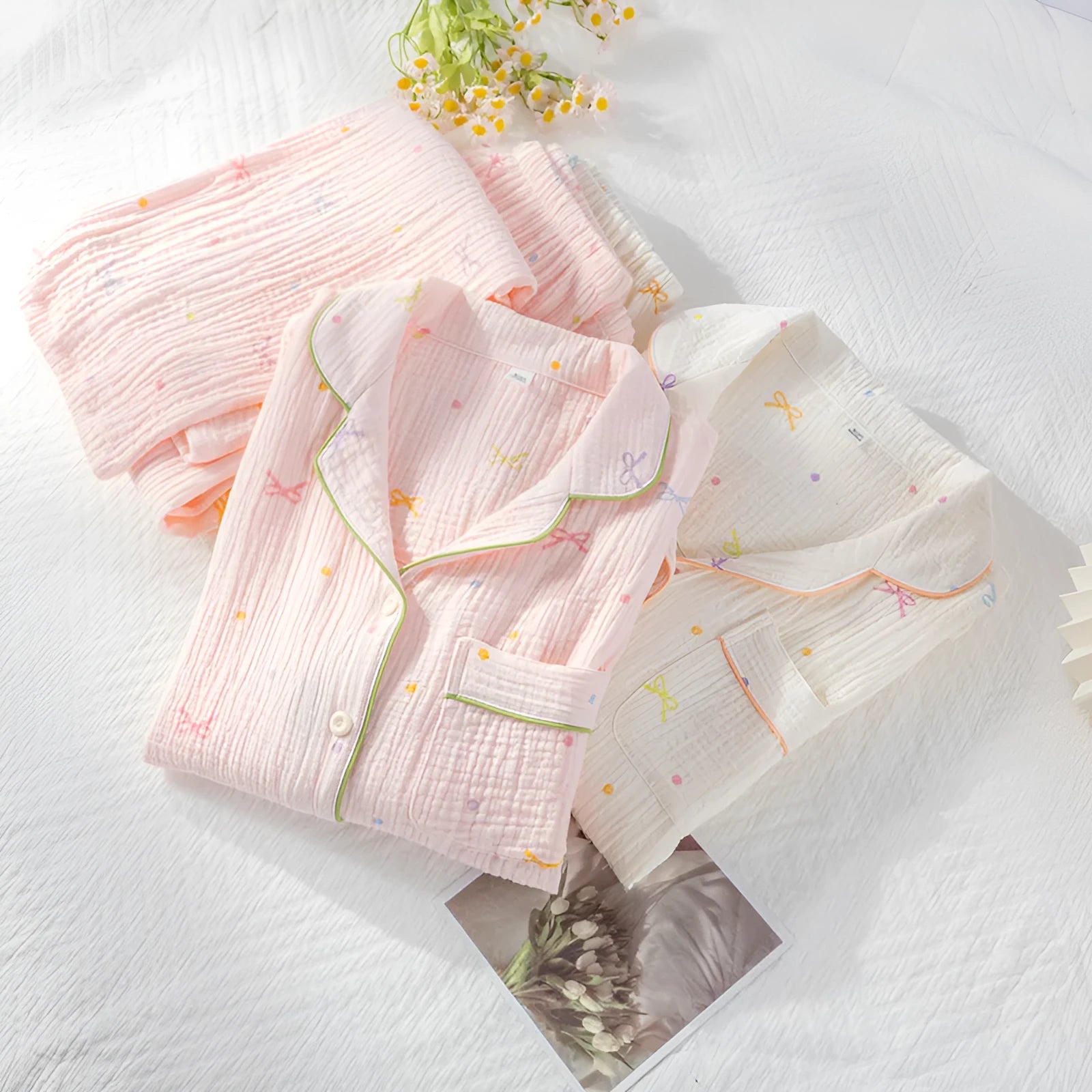 Women's beige thin cotton long sleeve pajama top and trousers set laid flat.