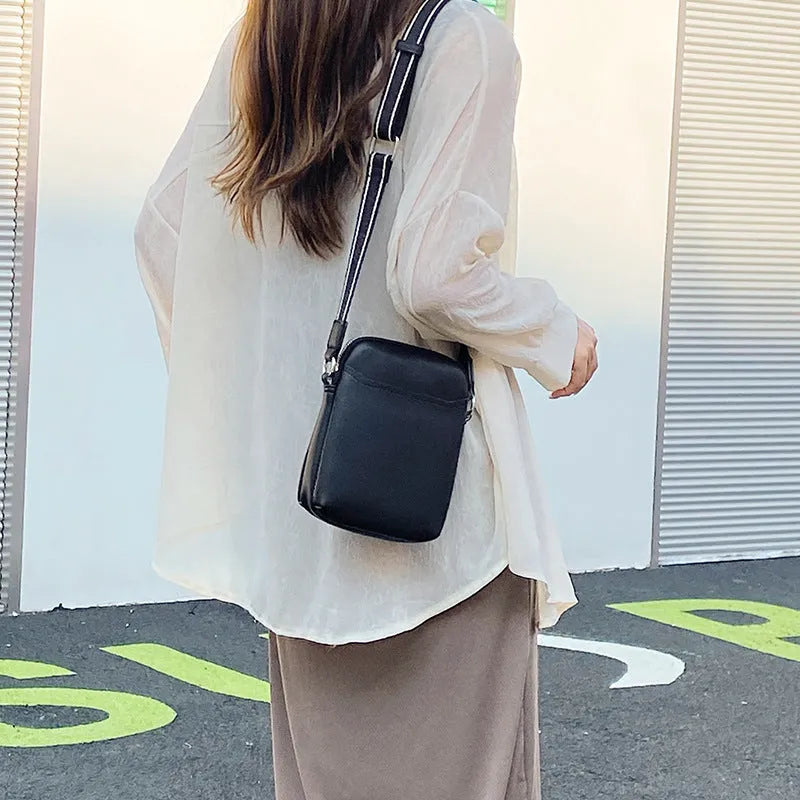 Solid colour PU leather crossbody shoulder bag for women with adjustable strap.