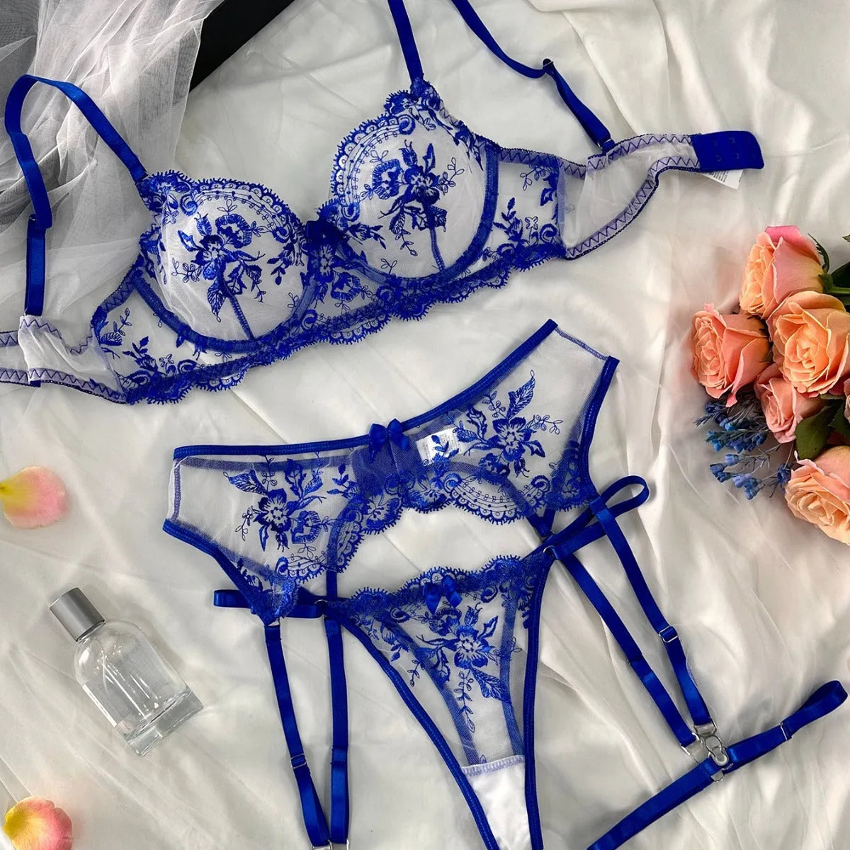 Women's sheer embroidered underwear set with cutouts and a detachable lace-up garter belt in three colour options.