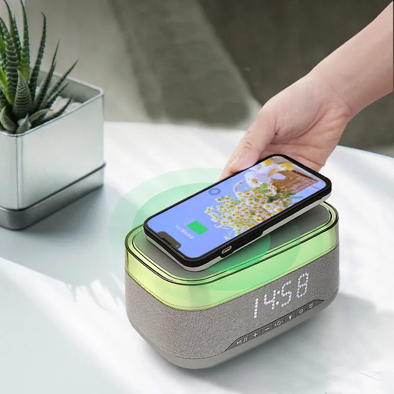 White multifunctional alarm clock with Bluetooth speaker and wireless charging pad on wooden table