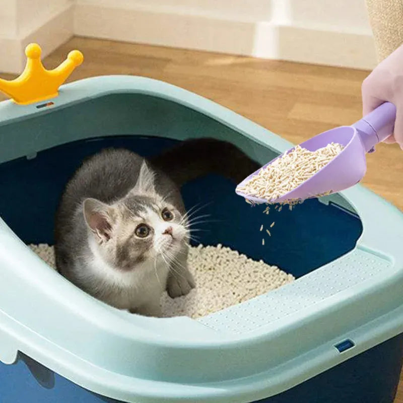 White ABS plastic cat litter scoop with a stand-up base and hidden bag storage compartment.