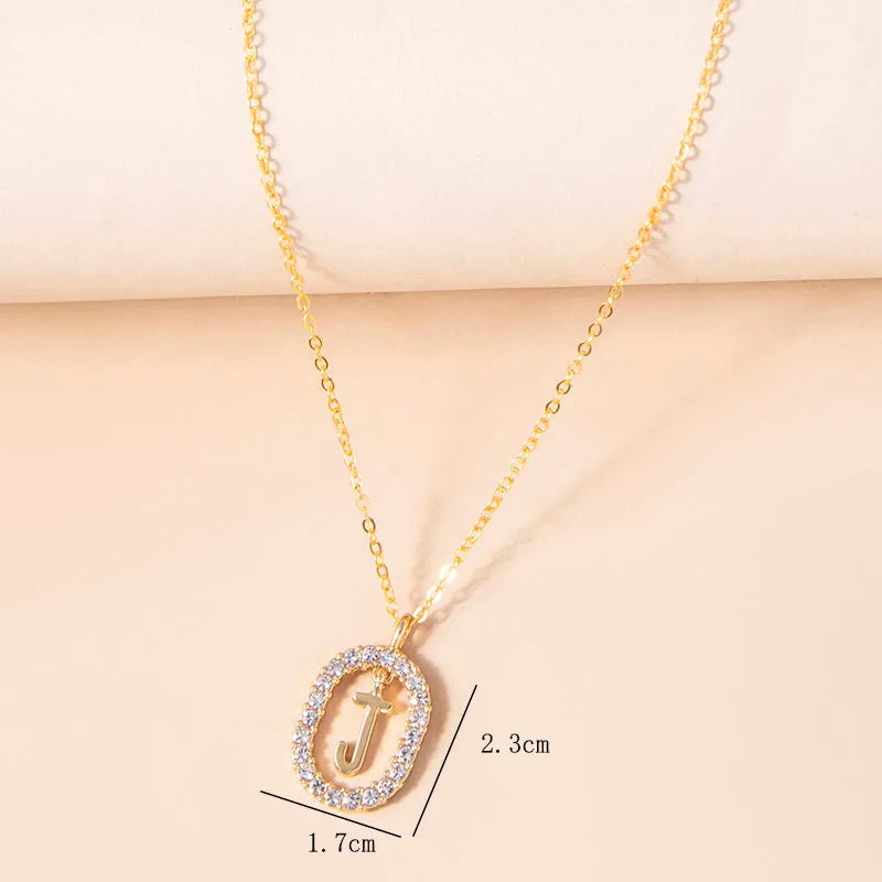 Gold crystal letter necklace with rhinestone initial on oval pendant and O-chain