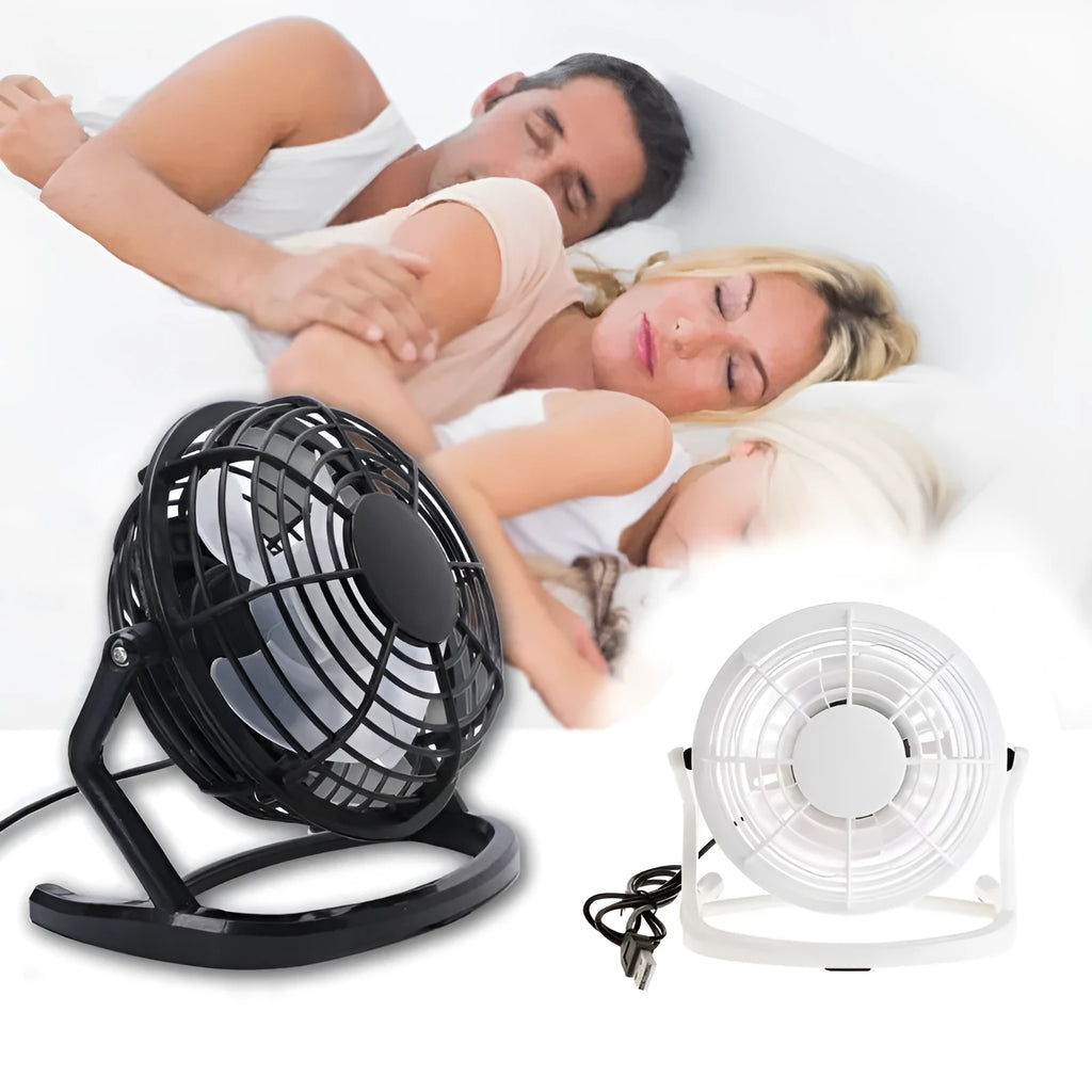 Compact black mini USB desk fan with adjustable tilt on a desk next to a laptop.