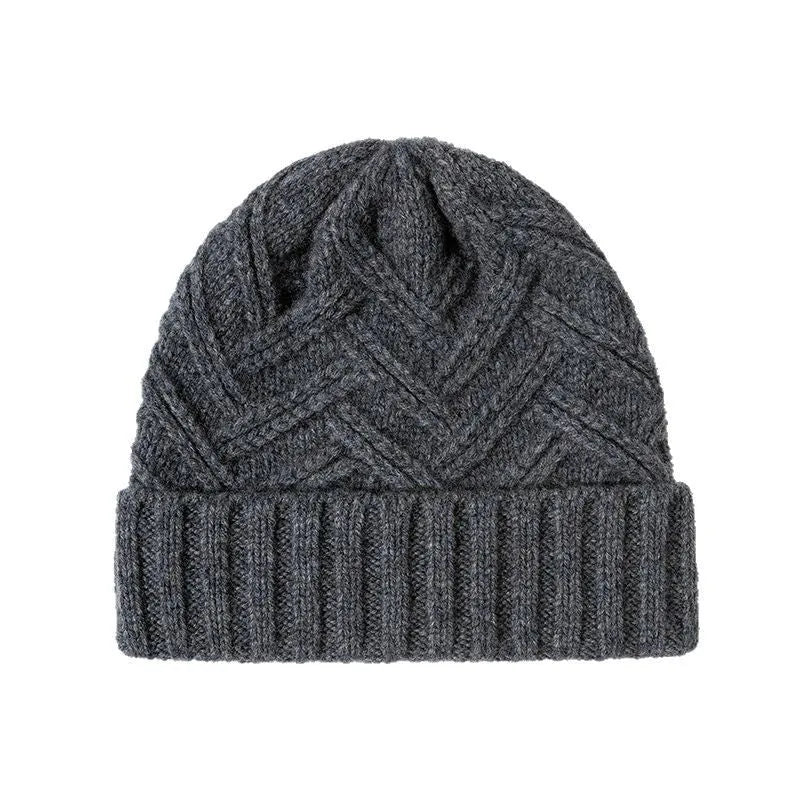 Woman wearing a knitted wool beanie with a dome crown and tribal totem pattern in Ankela Red.