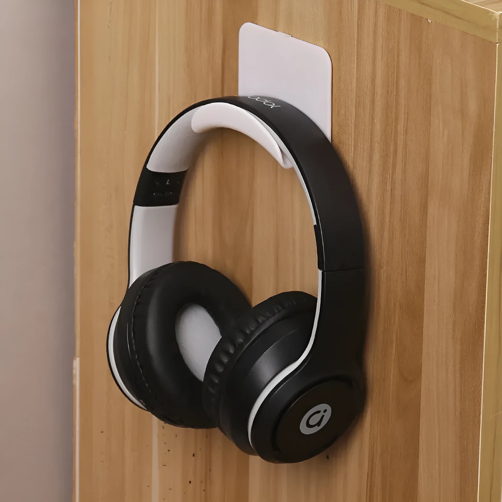 Black plastic headphone bracket mounted on wall with universal fit for headset storage