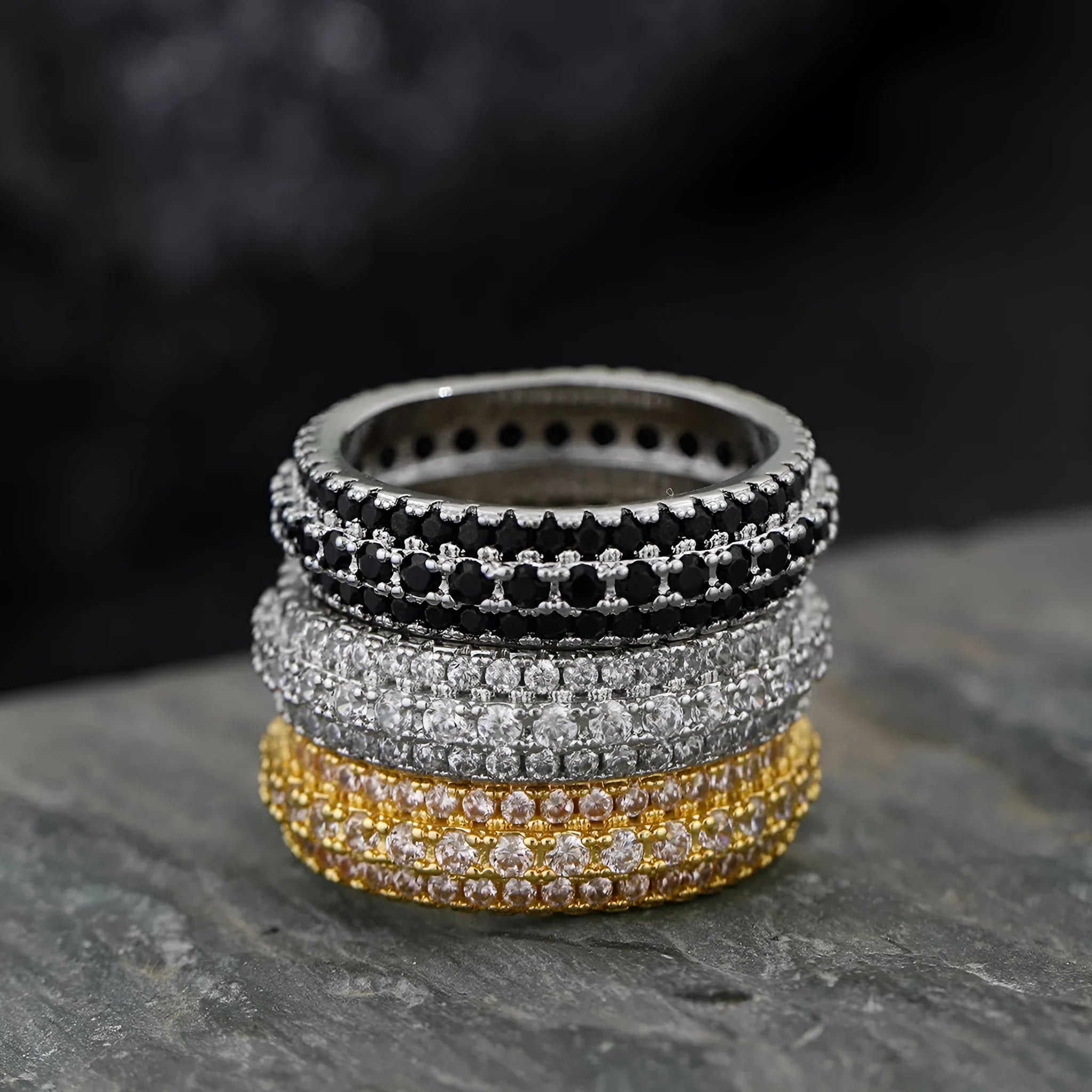 Triangular geometric ring with a zircon stone centre, shown in different metal plating colours.