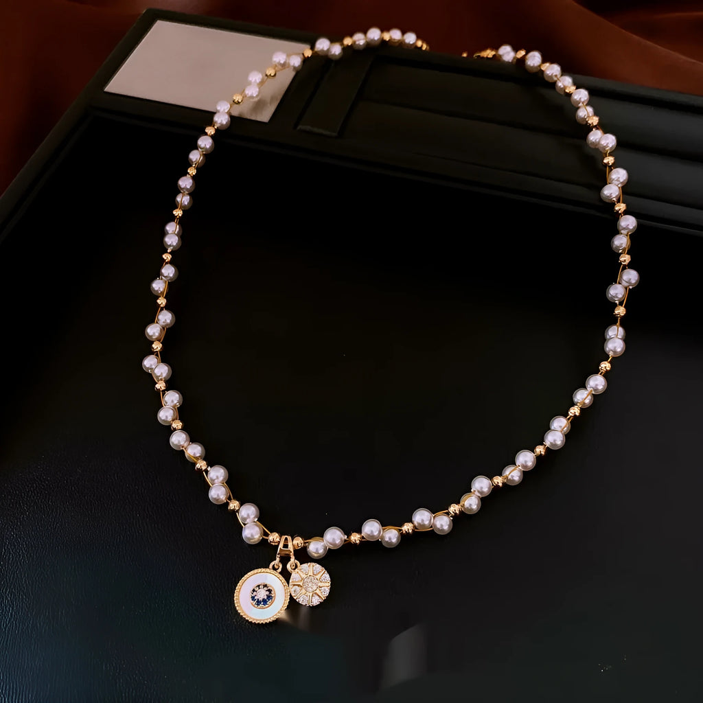 Gold electroplated necklace with round zircon and imitation pearl geometric pendant on an adjustable chain.